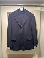 Front view of jacket on hanger, showing notch lapel, two-button closure and flap pockets