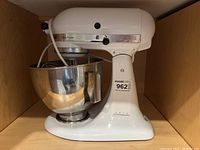 White KitchenAid mixer in cabinet, left-front view