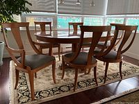 Six chairs arranged around a round dining table, showing overall set and upholstery pattern.