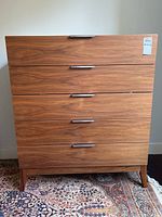 Front view showing rectangular shape, four drawers with chrome handles, and wood grain finish on teak wood.