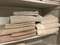 Five folded queen duvet cover sets on shelf in various colors and patterns