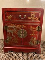 Front view showing drawer, doors, painted panels and brass hardware