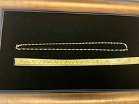 Full length of the gold chain with measuring ruler showing approximately 7 inches.