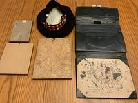 Overview of tam o' shanter hat, portfolio, and three photographs displayed