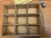 Close-up image of the wooden shelf showing nine compartments and its material.
