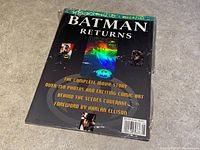 Front cover of Batman Returns Collectors Magazine 1991 showing holographic Batman logo card and listing contents including over 150 photos and foreword by Harlan Ellison.