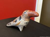Vintage Tonala burnished terracotta bird pottery figurine, showing front and side profile with detailed painted feathers and eyes.