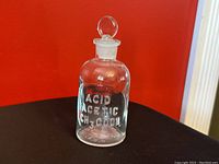 Front view of the vintage glass apothecary jar showing embossed label 'ACID ACETIC CH3COOH' and the glass stopper lid.