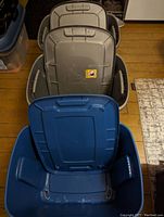 Three plastic storage bins stacked, two gray and one blue with their lids, showing general size and condition.
