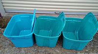 Three blue plastic storage bins placed side by side with their lids open upright showing inside of bins and lid design.