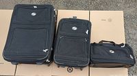Photo of 3 American Tourister luggage bags: one large wheeled suitcase, one medium wheeled suitcase, and one small carry bag.