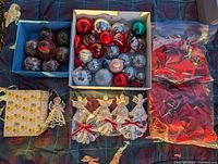 Lot of Christmas decorations with boxes containing assorted spherical ornaments, crocheted angels, and bagged star-shaped decorations.