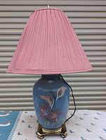 Photo of the entire lamp showing the blue glass base with floral painting, brass base and pink pleated shade.