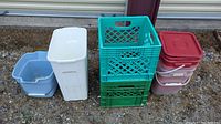 Overall lot showing all bins, baskets, and buckets arranged on ground outside