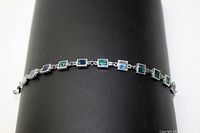 Full view of the 6.5-inch abalone and silver-toned bracelet shown on a black display surface.