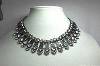 Front view of the black chain necklace with clear crystals on display bust showing collar style design.