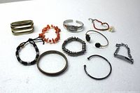 Full view of all bracelets and watch laid on white background showing variety of materials and styles.