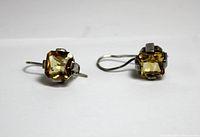 Pair of sterling silver earrings with square yellow citrine stones, side view showing the hook and setting.
