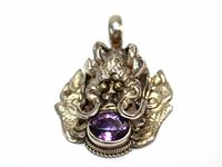 Close-up front photo of sterling silver pendant showcasing central oval amethyst gem and intricate stylized bug design