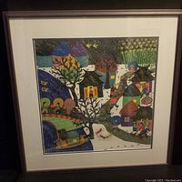 Framed watercolour print showing vibrant depiction of a Chinese village scene with colorful houses, trees, and people sweeping snow.