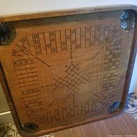 Top surface showing cribbage game layout with marked scoring tracks and holes in wood corners