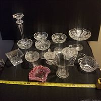 Full display of all crystal pieces arranged on black cloth with measuring tape indicating size range