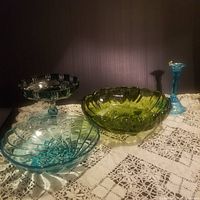 Four vintage cut to clear and colored glass serving pieces on crocheted white tablecloth, showing full lot arrangement and colors.