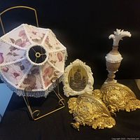 Photo showing whole lot including floral lampshade with gold metal stand, white framed religious plaque, gold ornate wall brackets, and decorative urn.
