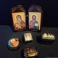 Front view showing complete lot with two-panel hinged icons and four lacquer boxes with detailed hand painted designs