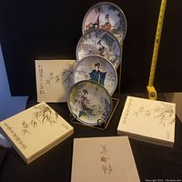 Four Imperial Jingdezhen Porcelain Plates artistically painted with female figures, shown with original boxes and display stand (stand not included).