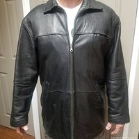 Front view of men's black leather coat with zipper closed and collar down