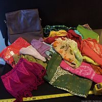 Photo of purse paired with assorted colorful scarves and pashminas showing a variety of textiles and patterns