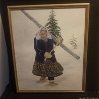 Full view of the oil painting showing a woman carrying a log with trees in the background and framed in a wooden frame.