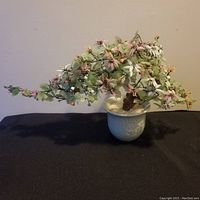Full view of vintage jade bonsai tree with pink and white blossoms in celadon pot
