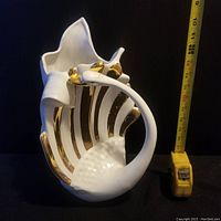Side view of the vintage white ceramic swan vase with a measuring tape showing height.