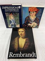 Three large hardcover fine art books shown from the front cover; titles are 'Impressionist Masterpieces', 'Great French Paintings', and 'Rembrandt'.