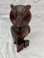 Front view of hand carved wood owl sculpture showing detailed facial features and feet.
