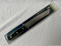 Full view of the bread cutter knife in sealed packaging showing black handle and serrated blade with Fine Edge Pro branding.