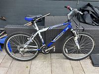 Side view of the Infinity Telluride mountain bike showing full profile with blue and white frame and knobby tires
