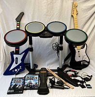 Front view showing assembled drum kit, two guitars, games, pedal, mic, sticks, cables