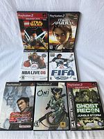 Seven Sony PlayStation 2 games arranged in two rows showing cover art and titles clearly.