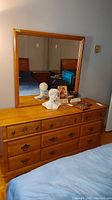 Photo of the full dresser with mirror on top against a wall, showing details of the drawer handles and the finish.