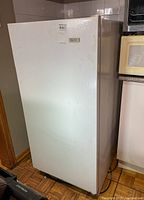 Front and side view of Beaumark upright freezer showing overall condition with minor surface discoloration.