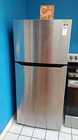 Front view of LG refrigerator showing stainless steel top freezer door and lower fridge door.