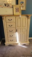 Front view of cream painted wood dresser showing five drawers and one door with decorative corbels and carved base detail