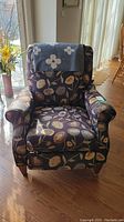 Front view of the recliner chair showing floral pattern and draped cloth on backrest.