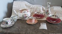 Full lot view showing teapot, cups, saucers, and vase on counter
