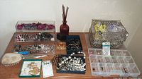 View showing multiple clear organizers holding assorted costume jewelry, amber perfume bottle, and reed scent sticks bottle.