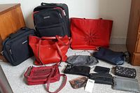 Wide view showing all items in the lot including two suitcases and multiple purses.