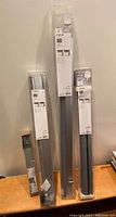 Three Ikea FYRTUR blackout blinds and one Rationelle blind still in original packaging positioned upright on a wooden surface.